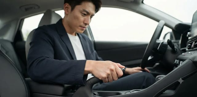 알림을 끄기 위해 확실하게 제동 장치 레버를 아래쪽으로 꾹 눌러 내리는 장면 주행 전 안전을 위해 손으로 레버를 조작하며 사이드 브레이크 해제 확인 모습