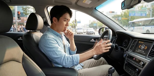신호 대기로 멈춰있는 상황에서 극심한 정차 중 핸들 떨림 증상에 스트레스받는 모습